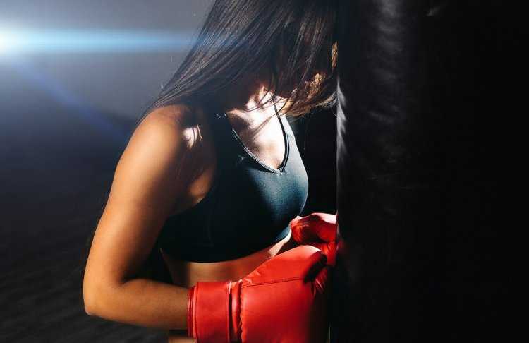 Девушка в боксерских перчатках со спины