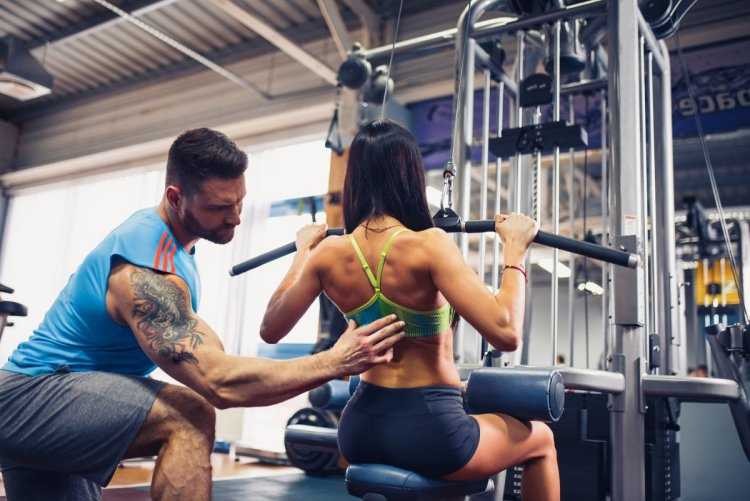 Тренер девушка в тренажерном зале