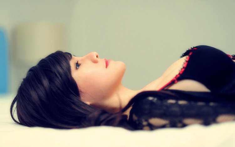 Девушка брюнетка лежит