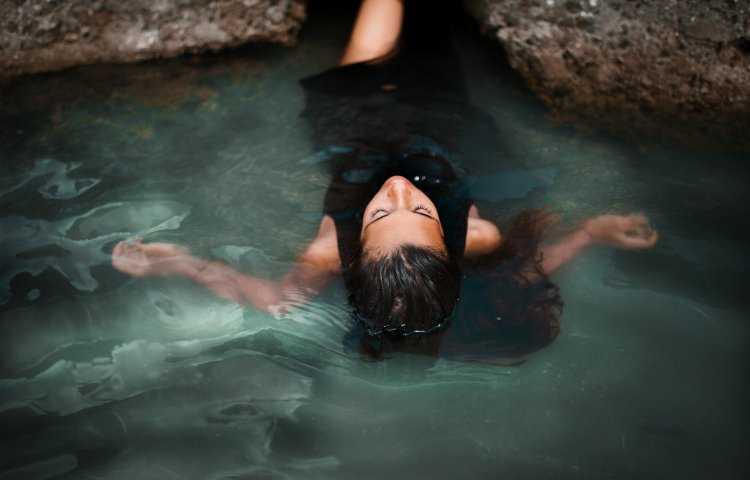 Девушка в воде со спины