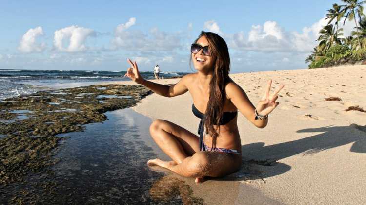 Девушка брюнетка в очках на пляже