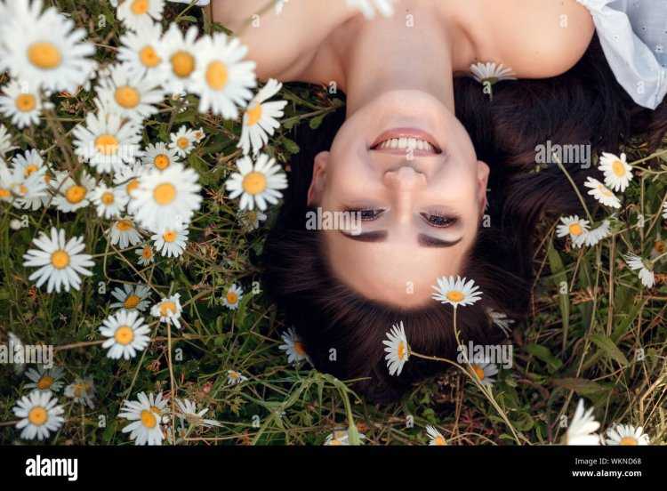 Девушка лежит в ромашковом поле