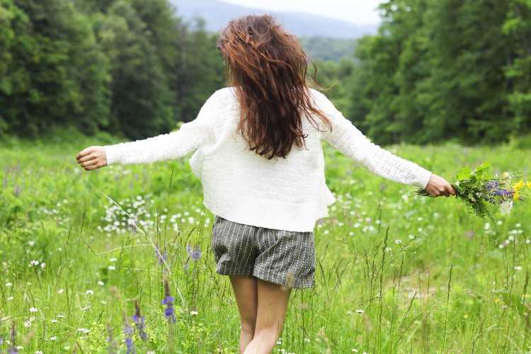 Девушка в ромашковом поле со спины