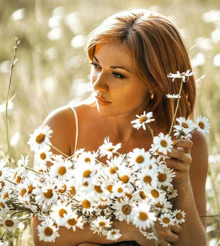 Обнадеженная девушка в ромашковом поле