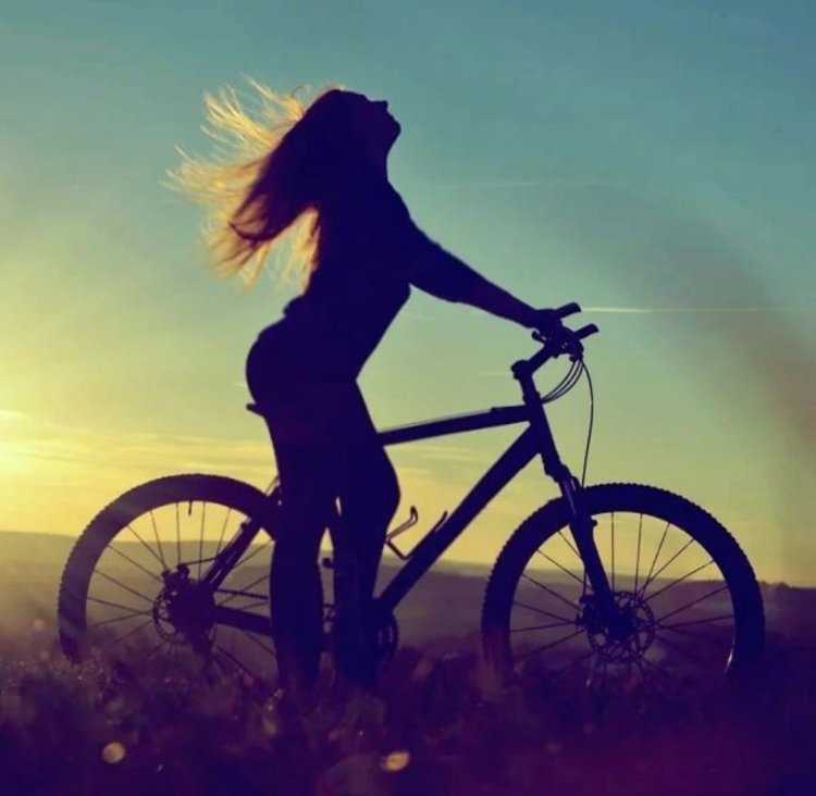 Девушка на велосипеде на закате