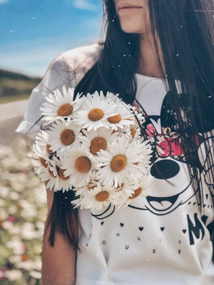Брюнетка с букетом ромашек