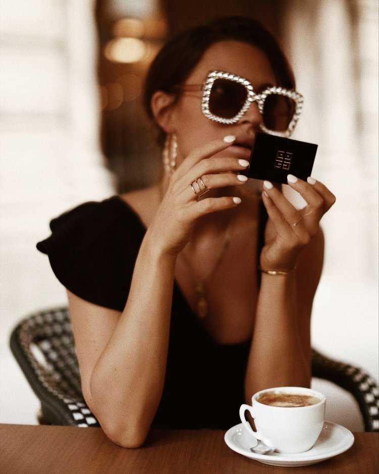 Сексуальная дама в гламурном образе с чашкой кофе