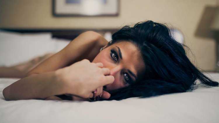 Девушка брюнетка лежит