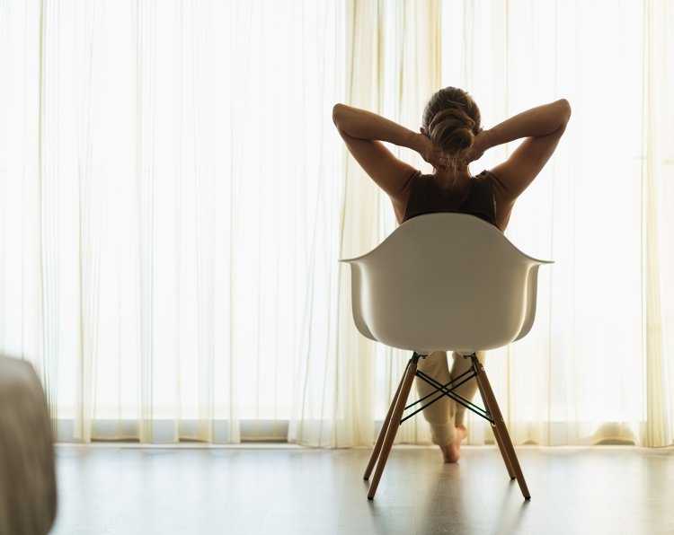 Девушка сидит на стуле спиной