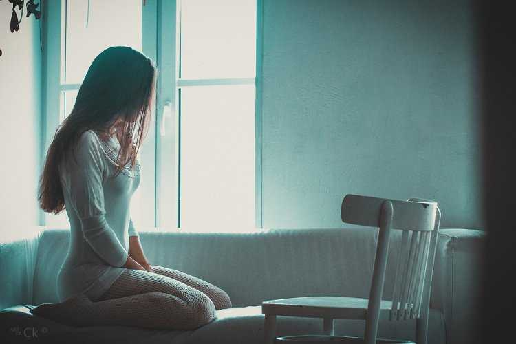 Девушка сидит на стуле спиной