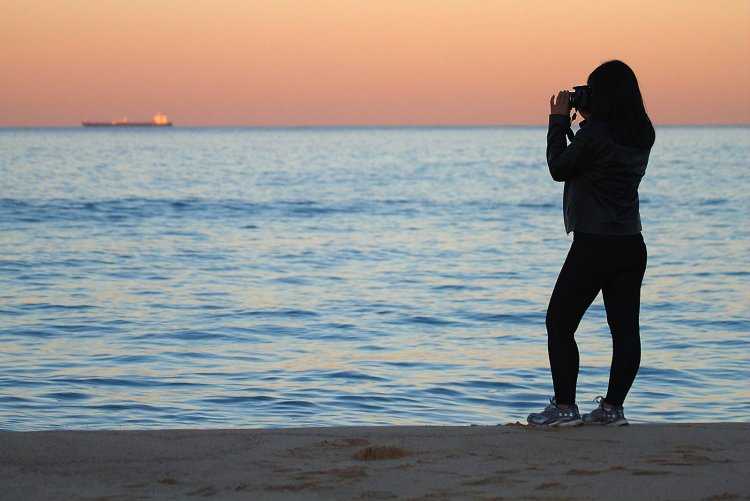 Женщина на берегу моря со спины