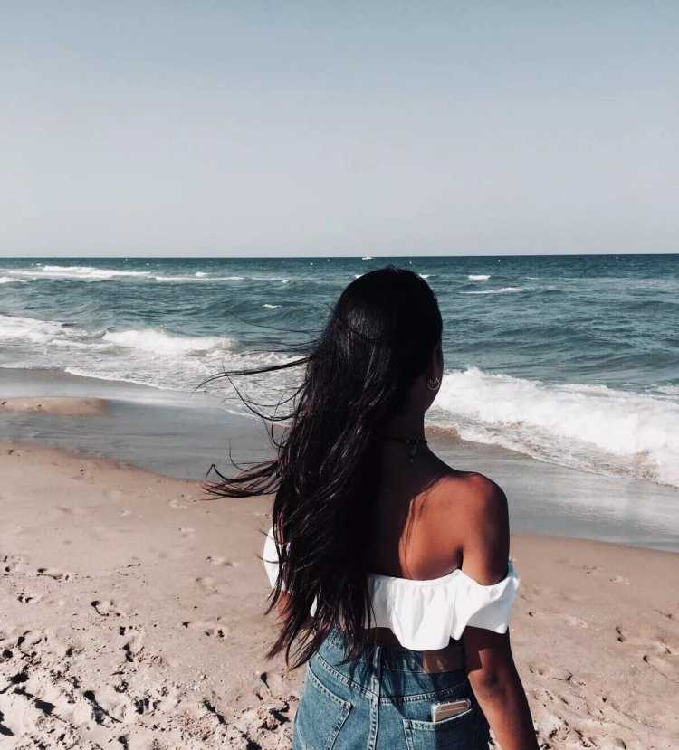 Брюнетка с длинными волосами на море