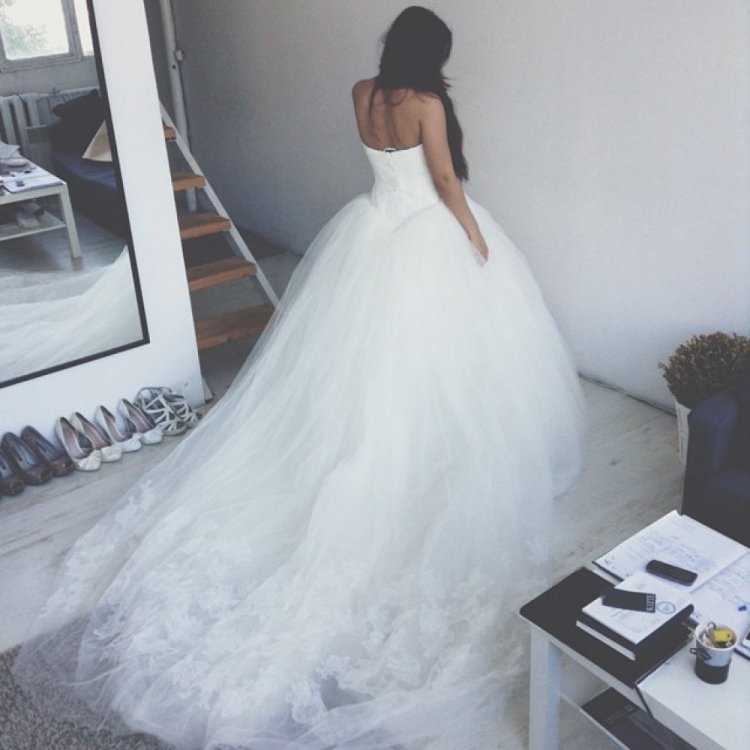 Брюнетка в свадебном платье со спины примерка