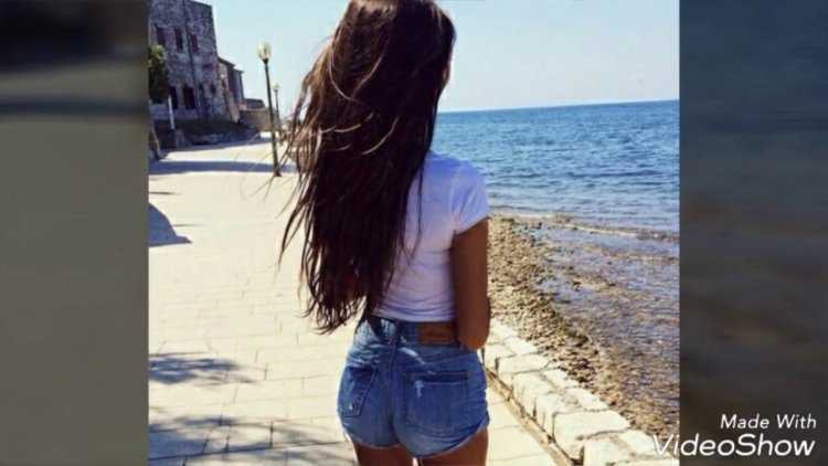 Девушка брюнетка со спины с длинными волосами на море