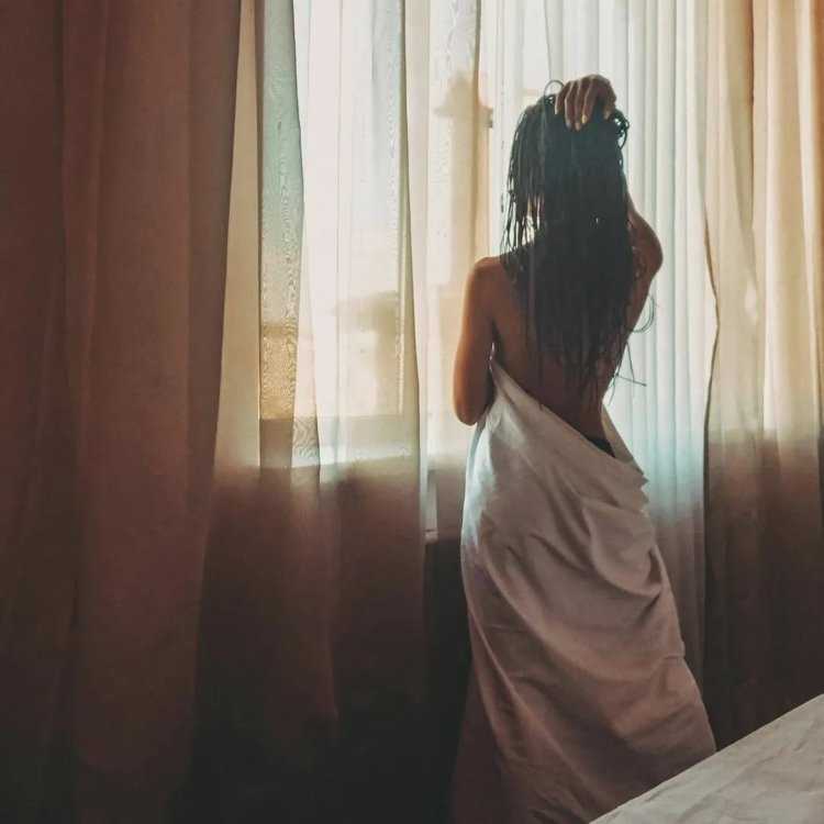 Девушка в одеяле без лица у окна