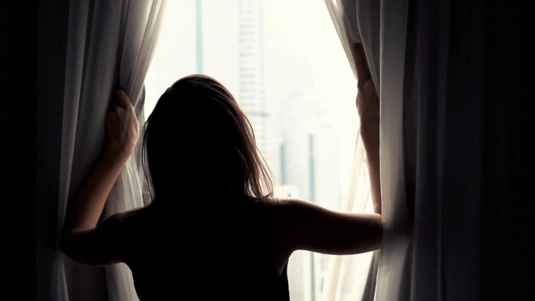 Девушка у окна со спины