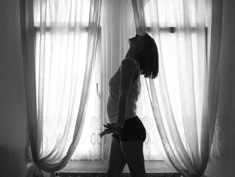 Брюнетка у окна со спины