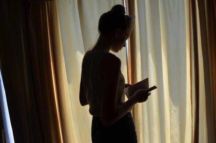 Девушка у окна со спины