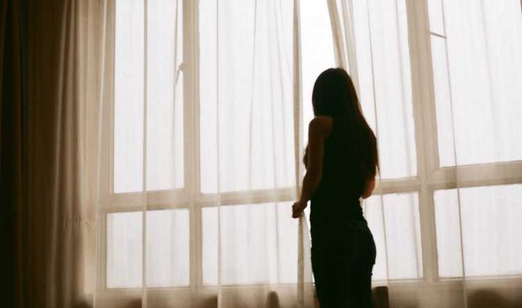 Девушка у окна со спины