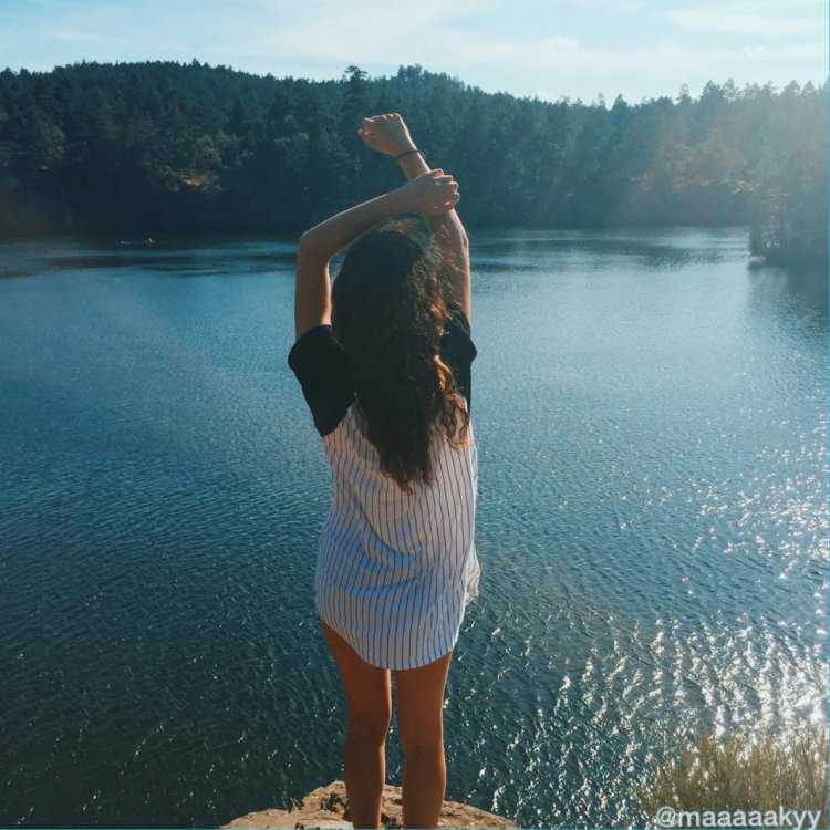 Девушка у реки со спины