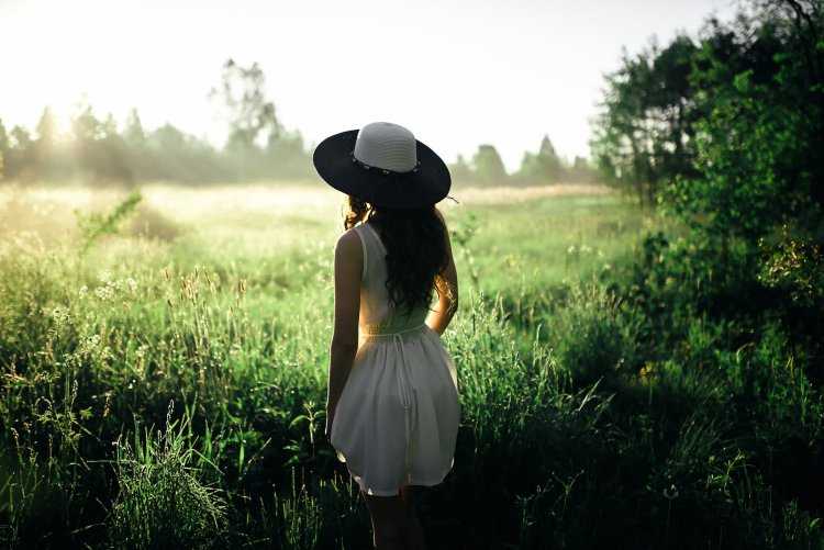 Девушка в летней шляпе со спины