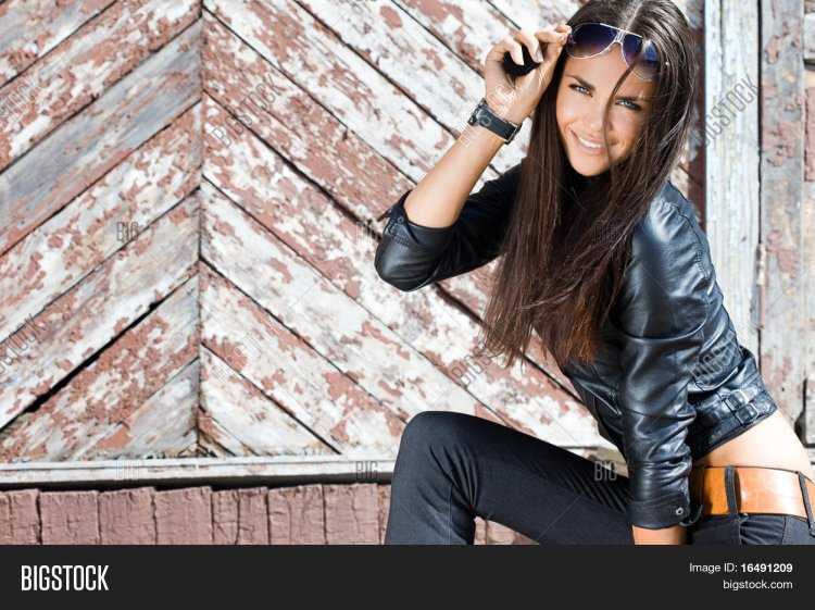 Брюнетка в кожаной куртке и джинсах