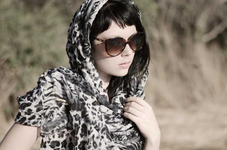 Девушка в тёмных очках и платке