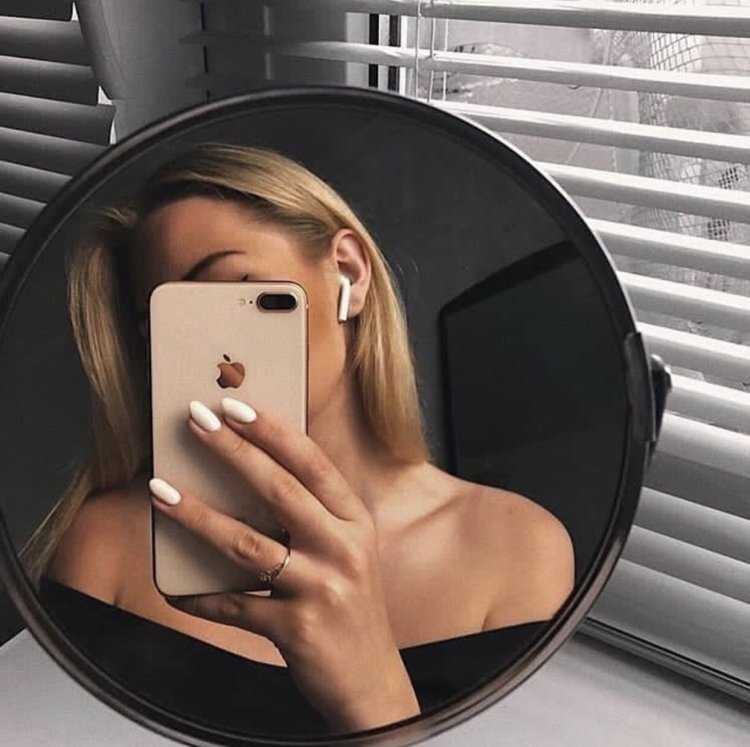 Девушка с айфоном в зеркале