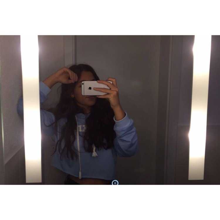 Девушка с темными волосами в зеркале