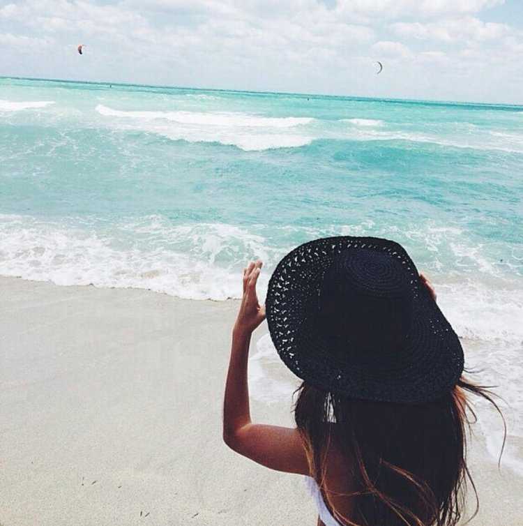 Брюнетка в шляпе на море