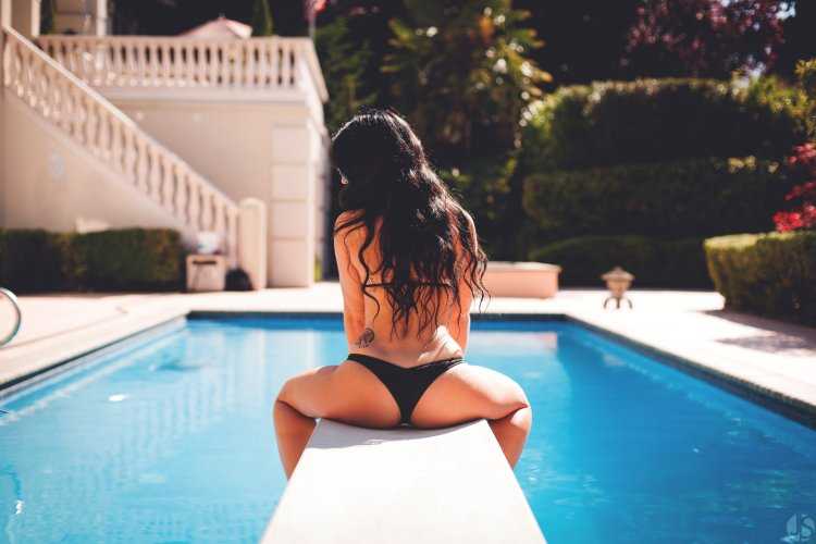 Красивая брюнетка в бассейне