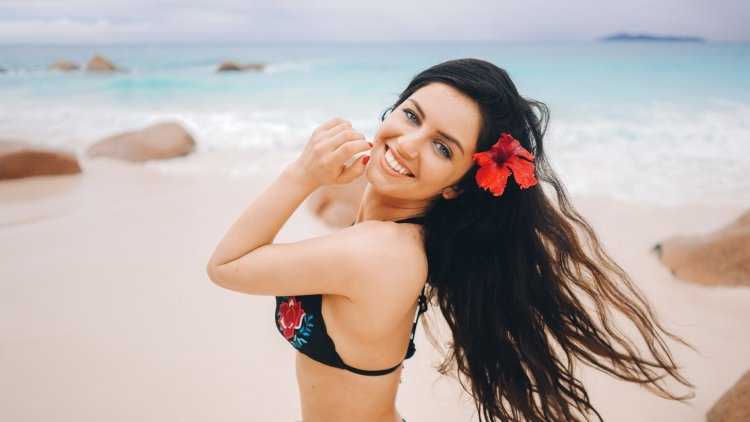 Девушка с цветами в волосах на пляже