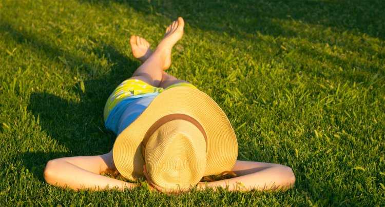 Женщина загорает на траве