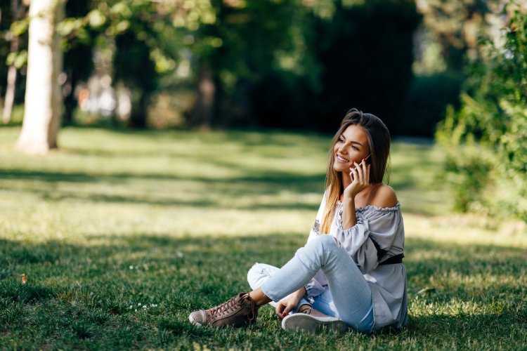 Приглушенная красота девушки, раскинувшейся на зеленой травке