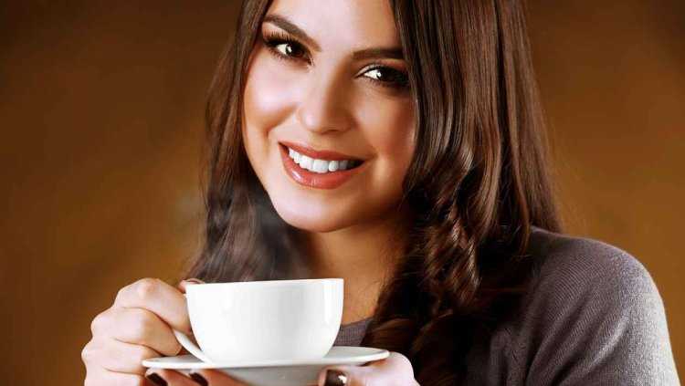 Спортсменка улыбается с чашкой