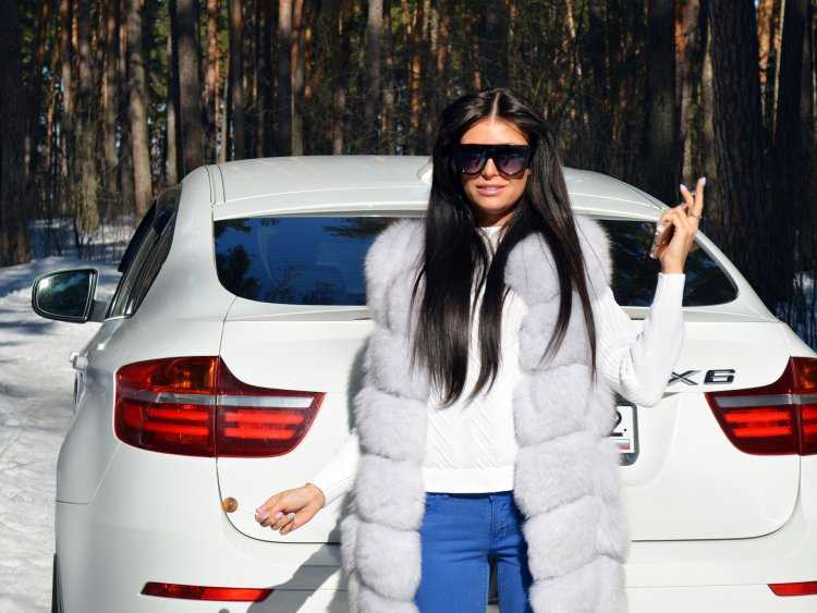 Девушка в шубе возле машины