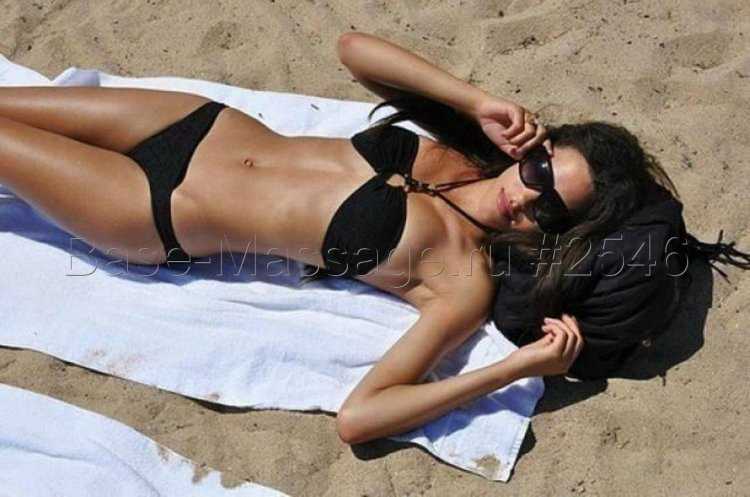 Брюнетка в черном купальнике на пляже