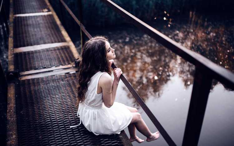 Девушка сидит на мостике