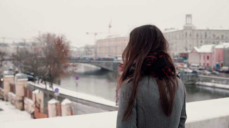 Девушка зимой в городе со спины