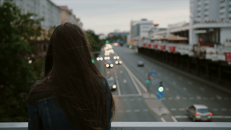 Девушка на мосту со спины