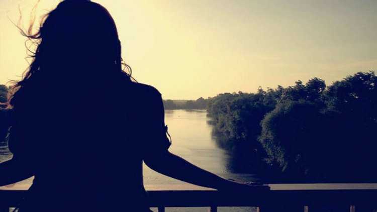 Девушка на мосту со спины