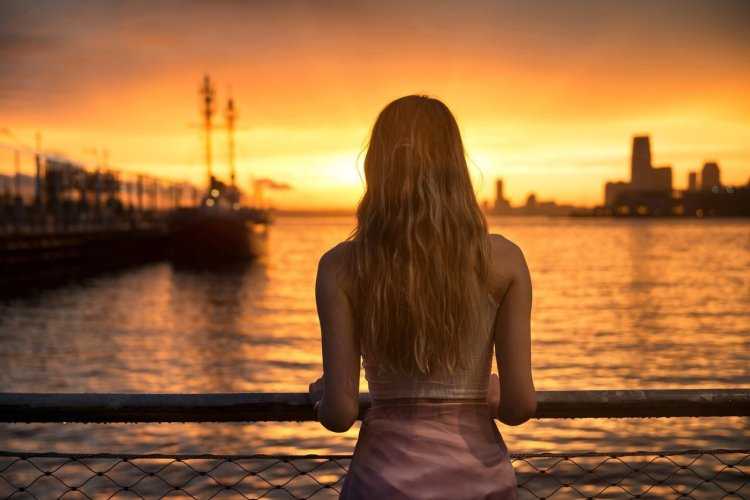 Девушка на мосту со спины