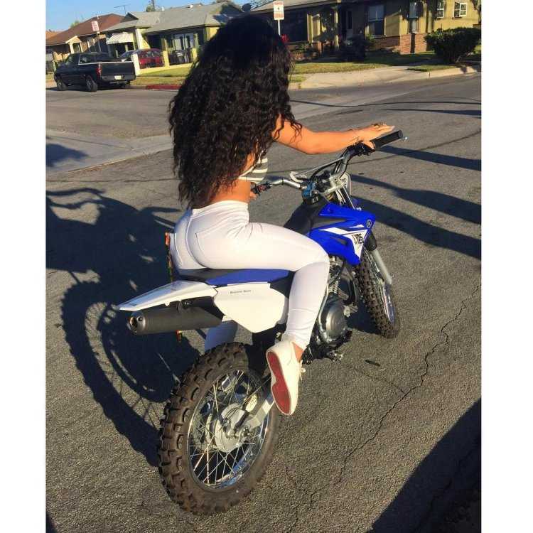 Брюнетка на мотоцикле со спины