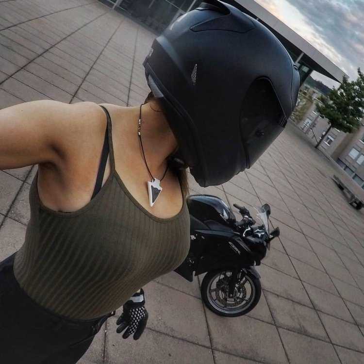 Девушка на мотоцикле в шлеме селфи