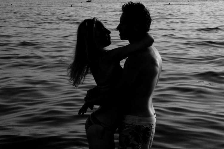 Парень обнимает девушку на море