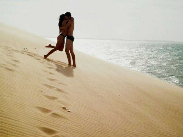 Брюнетка на пляже с парнем