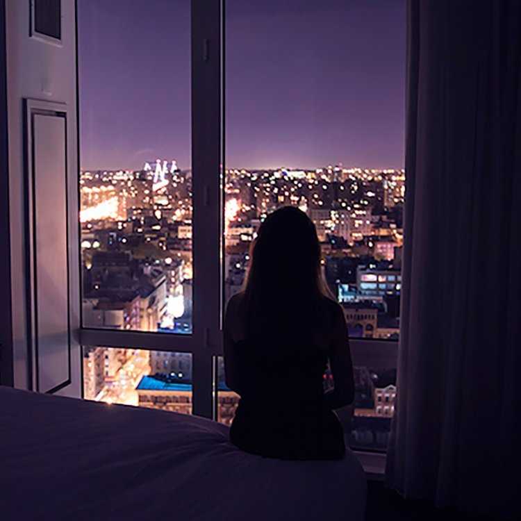 Девушка у окна ночного города
