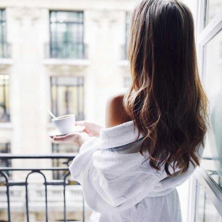 Женщина с чашкой у окна