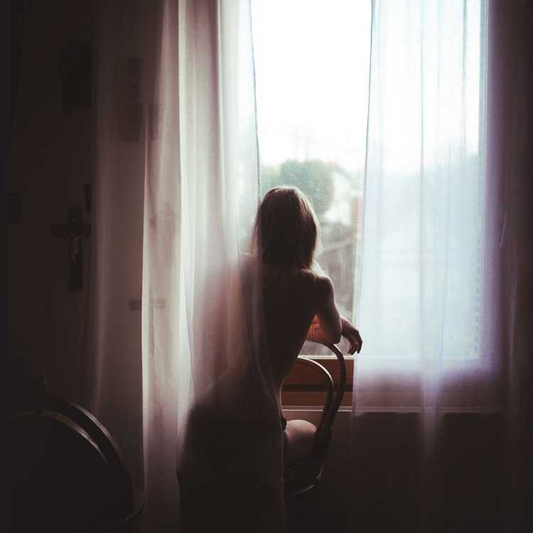 Девушка у окна со спины