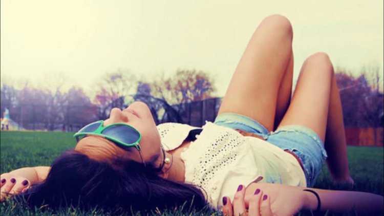 Брюнетка сидит на траве